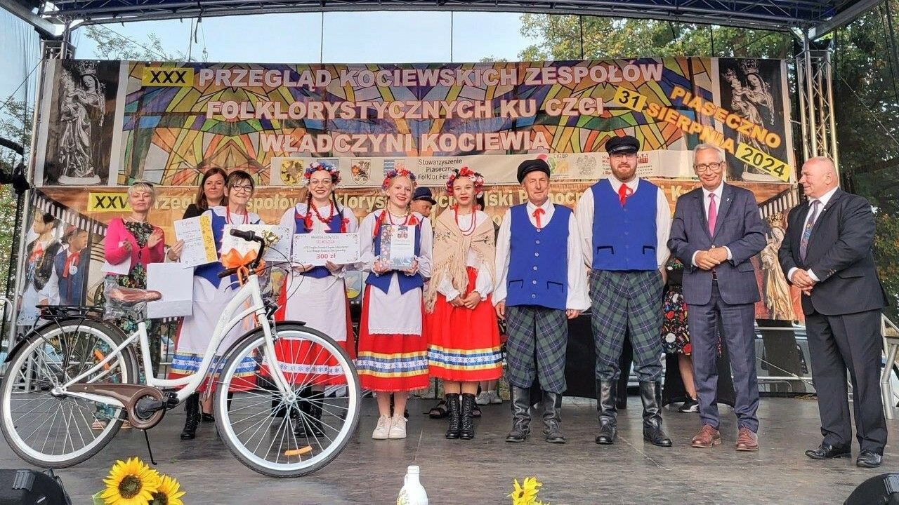 człnkowie zespołu Kociewska Familija w regionalnych strojach stoją wspólnie za sceną